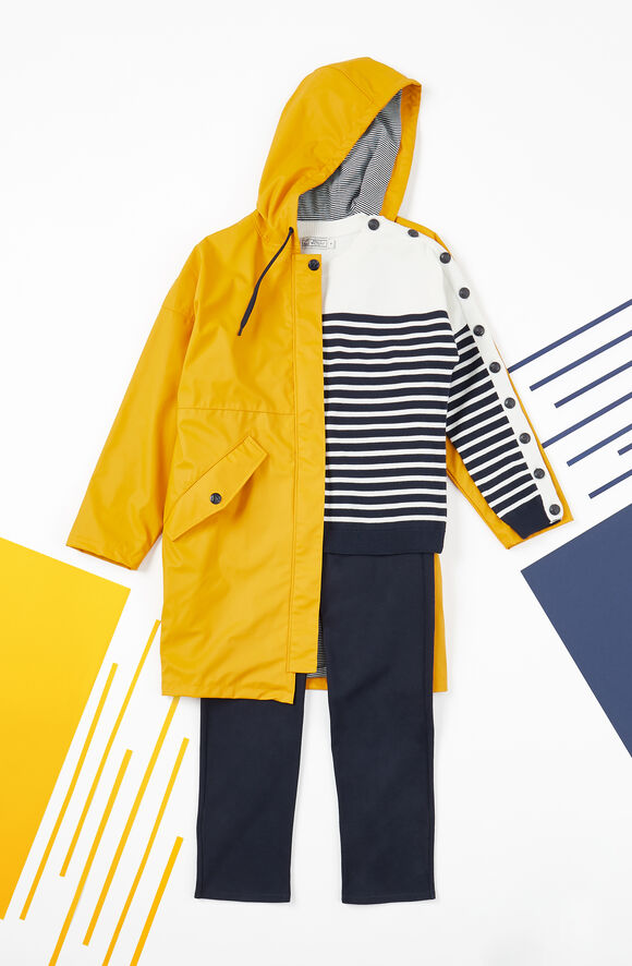 Look marin avec un ciré jaune pour femme, un pull marinière et un pantalon droit noir. 